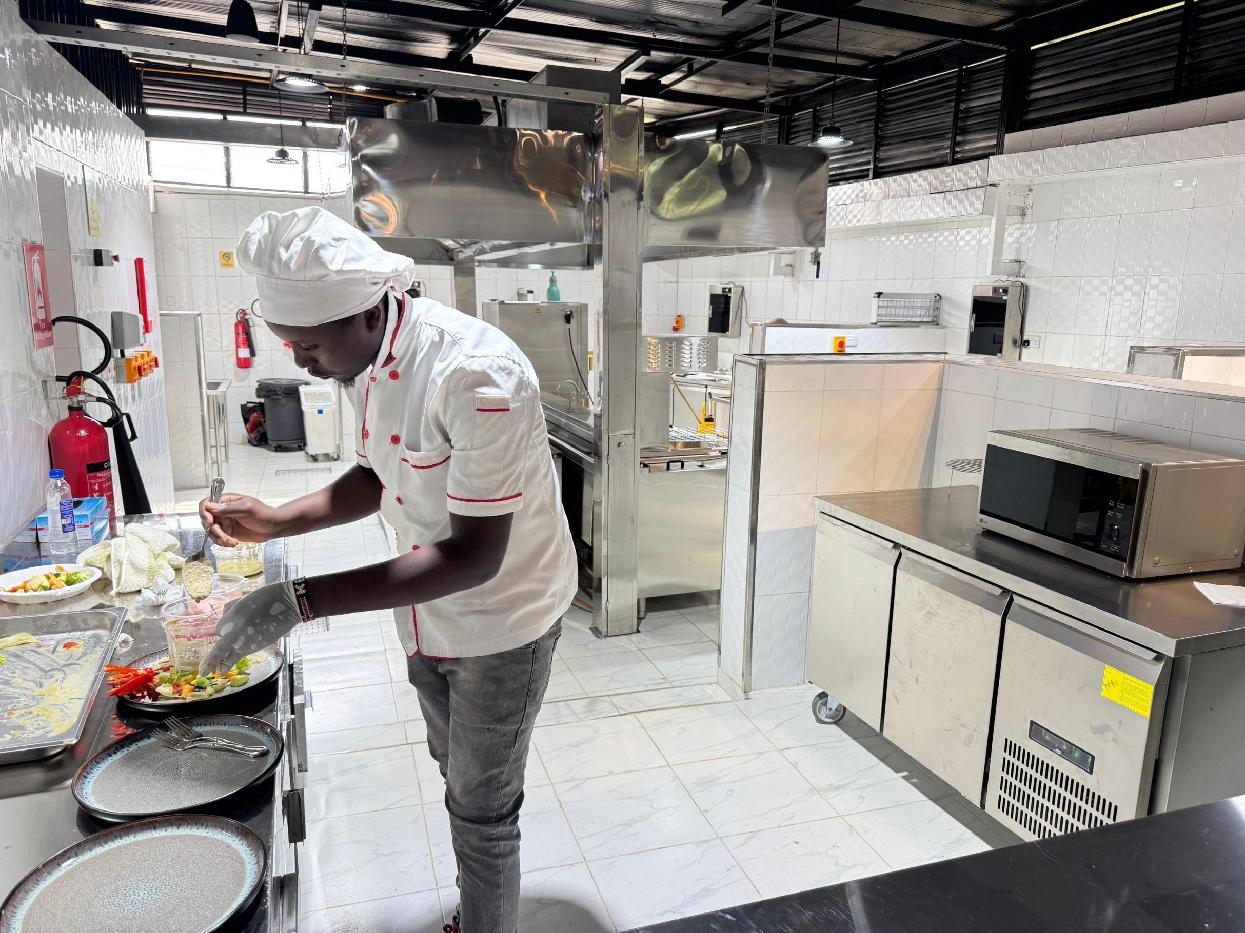 Chef preparing dishes in the completed Cobblestone House restaurant kitchen in Nairobi, Kenya